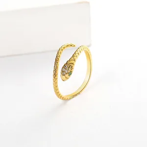 Close-up of golden snake ring featuring micro-inset green and white zircon stones