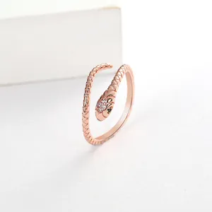 Detailed close-up of a rose gold snake ring with micro-pave zircons and scale textures