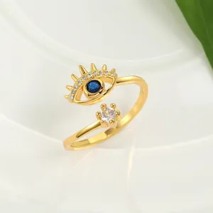Dettaglio dell'anello dorato a forma di occhio di Allah con cristalli blu e bianchi