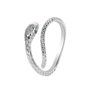 Detail shot of a silver snake ring featuring green gem eyes and sparkling zircons