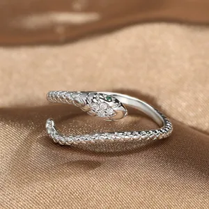 Elegant snake-shaped open ring in silver with green gemstone eyes and micro-inlaid diamonds