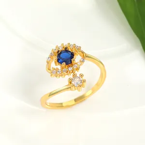 Detail of gold evil eye ring with blue stone and sparkling diamonds on white ceramic