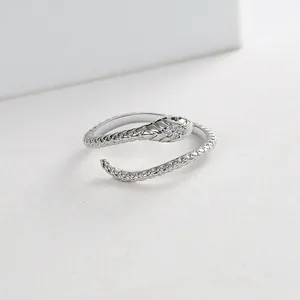 Close-up of silver snake ring featuring green gemstone eyes and micro-paved zircons