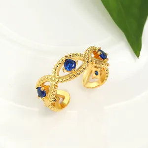 Detailed view of adjustable gold ring with three blue stones and beaded texture