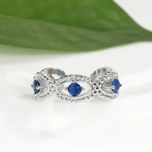 Detailed macro view of an adjustable silver Evil Eye ring with blue round gemstones
