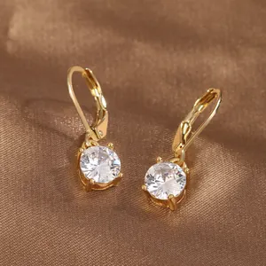 Détail de boucles d'oreilles plaquées or avec zircons ronds sertis à quatre griffes