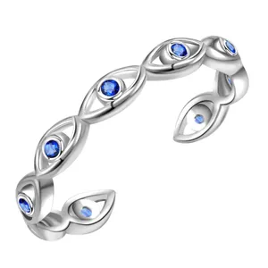 Macro detail of silver evil eye open ring with inset dark blue sapphire gemstones