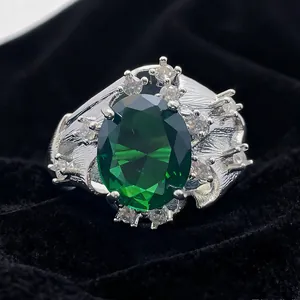 Luxurious silver ring with large oval green gemstone and textured feather band design