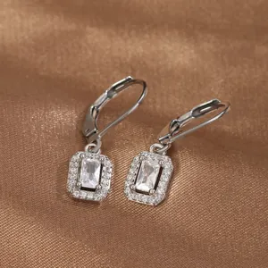 Detailed view of silver leverback earrings with rectangular cubic zirconia on satin background