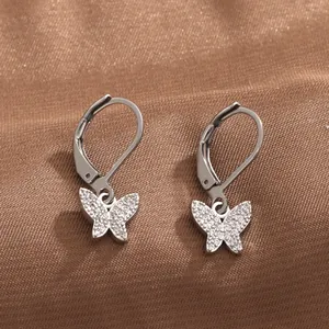 Détail de boucles d'oreilles dormeuses argentées avec papillons sertis de zircons