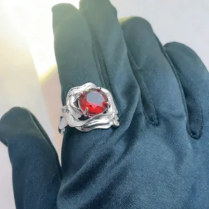 Elegant silver ring featuring a large faceted round red ruby set in a floral petal mounting