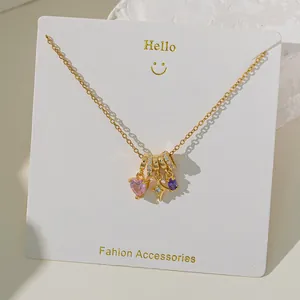 Detailed view of gold chain necklace with colorful heart, star, and oval crystal charms