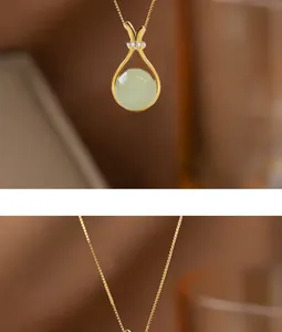 Dettaglio della collana dorata con cornice a goccia e ciondolo in giada verde