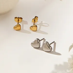 Boucles d'oreilles cœur minimalistes en or 18 carats et acier argenté sur fond blanc