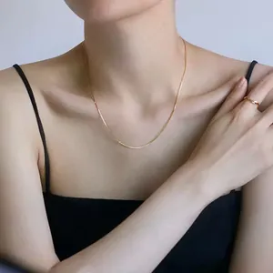 Minimalist gold snake chain necklace for women styled with matching round gold ring
