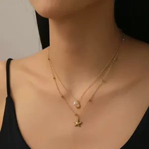 Collier double rang doré avec pendentifs coquillage et étoile de mer sur mannequin