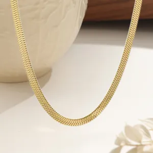 Elegant gold-plated stainless steel flat snake chain necklace on minimalist ceramic decor