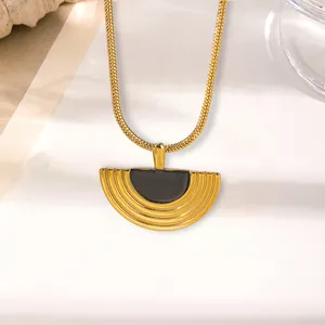 Dettaglio ravvicinato di una collana a semicerchio d'oro con intarsio nero e texture