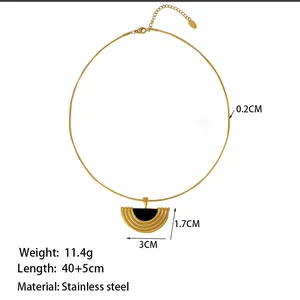 Dettaglio macro della collana in acciaio dorato con inserto nero e misure del ciondolo