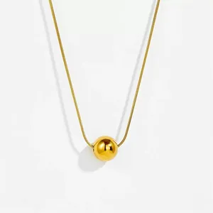 Minimalistische goldene Schlangenkette mit hochglanzpoliertem Kugelanhänger auf weißem Grund