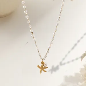 Elegante collana di perle con ciondolo a stella marina in oro opaco su fondo beige
