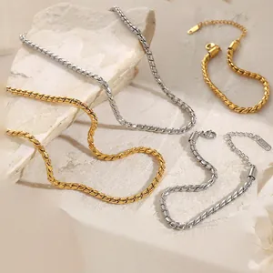 Elegant gold and silver twisted chain necklaces with K18 tag on stone background