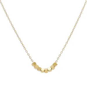 Collar dorado minimalista con siete cuentas de cubo en una fina cadena de eslabones
