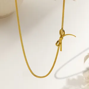 Elegant gold flat snake chain necklace featuring a minimalist knot bow pendant detail
