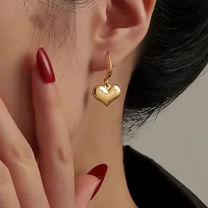 Orecchini a cuore in oro lucido su modella per un look vintage francese chic