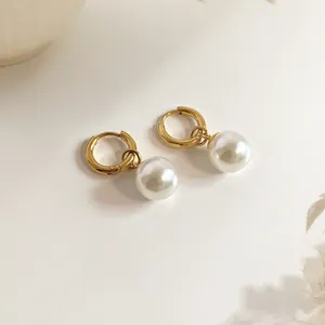 Detailed view of 18K gold plated hoop earrings with elegant white pearl charms