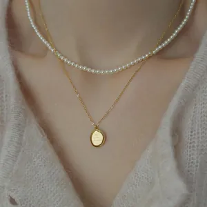 Conjunto de collares dorados a capas con perlas blancas y colgante de letra ovalado