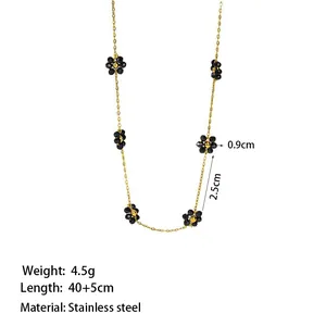 Elegante collana in acciaio inossidabile con catena dorata e piccoli ciondoli a fiore nero
