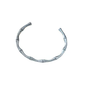 Polished silver stainless steel open bangle featuring a minimalist bamboo node design