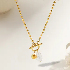 Macro detail of OT toggle clasp gold bead necklace with a white baroque pearl pendant