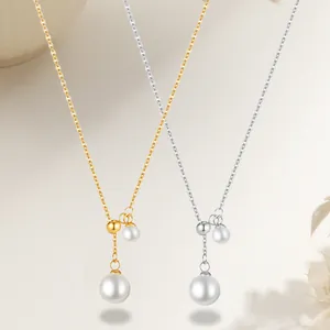 Detail of gold and silver Y-shaped necklaces featuring large oval pearls and beads