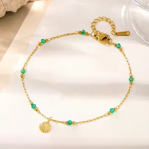 Dettaglio della collana con conchiglia dorata, perle verdi e incisione S.STEEL
