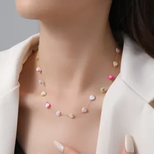 Collana dorata in acciaio con pendenti a cuore colorati su una modella molto elegante