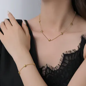Elegant gold heart pendant necklace and bracelet jewelry set for women on model