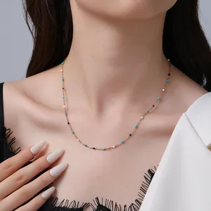 Collana in acciaio dorato con perline di pietra naturale blu indossata da una modella