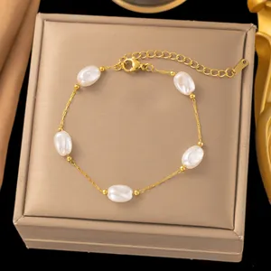 Close-up of gold stainless steel necklace with white pearls and beads on jewelry box