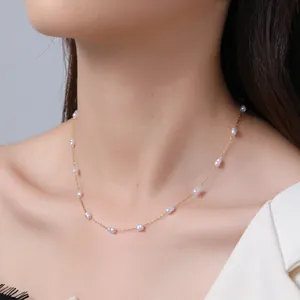 Nahaufnahme einer minimalistischen Perlenkette aus Gold auf dem Schlüsselbein eines Models