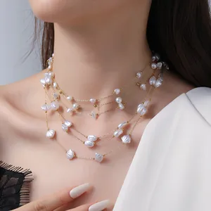 Elegant multilayer pearl necklace with gold chains and shell charms on model