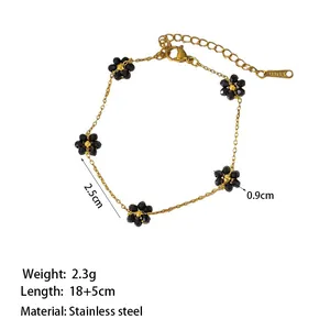 Dettaglio del bracciale a catena in acciaio inossidabile dorato con fiori di perline