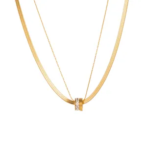 Dettaglio della collana dorata a due strati con catena a serpente e ciondolo in zircone