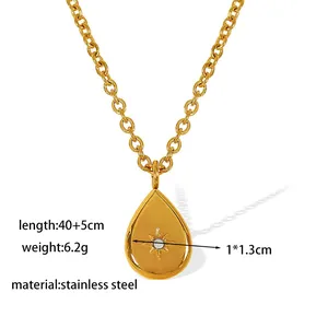 Gold stainless steel teardrop pendant necklace with starburst design and white crystal