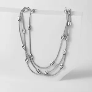 Dettaglio collana tripla a catena serpente argentata con perle di metallo lucido