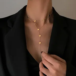 Collar de doble capa en oro con colgantes de corazón y cadena larga en Y en modelo
