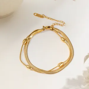Detail of 18K gold double-layer snake chain bracelet with metallic beads and clasp