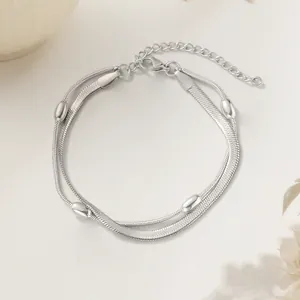 Detail view of double-layered silver snake chain necklace with oval beads and adjustable clasp