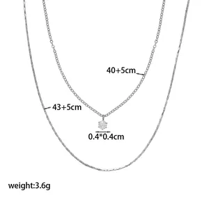 Detail showing double-layered silver necklace chain lengths and round zirconia pendant